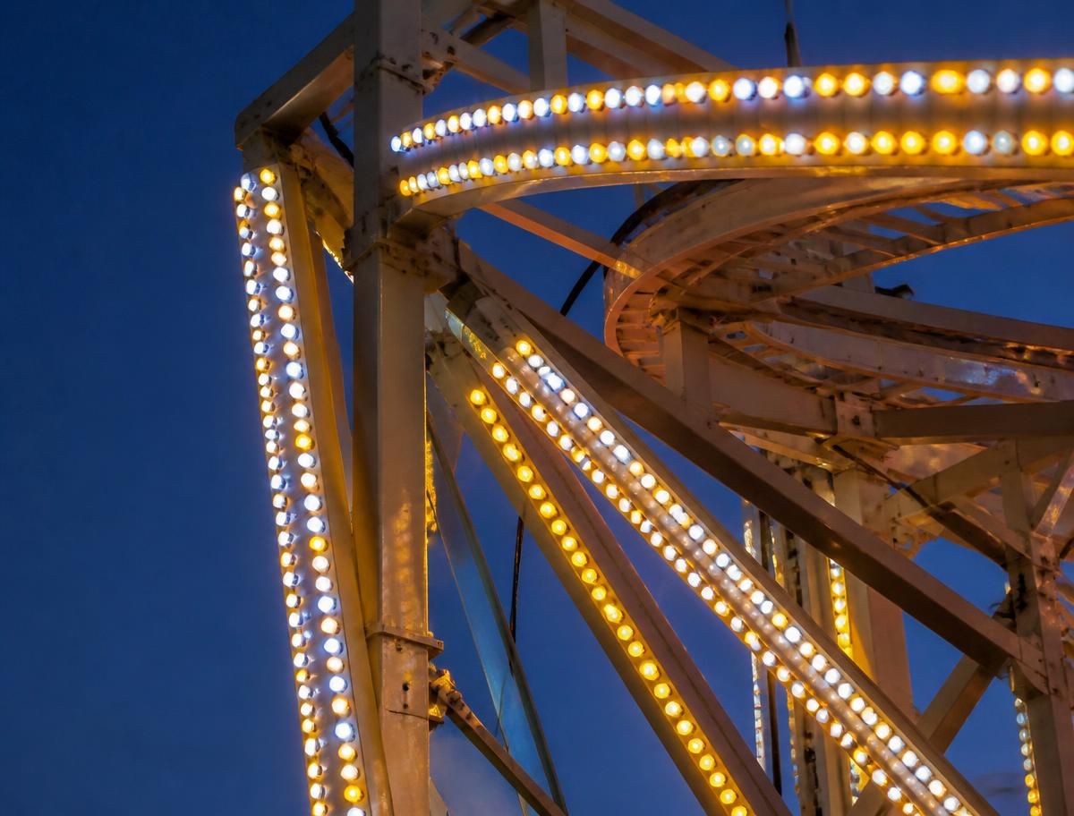 Leuchtende LED-Lichtleisten an einem Fahrgeschäft in der Dämmerung