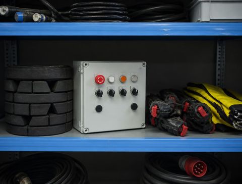 Control box, cables and accessory parts on a workshop shelf